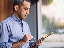 A man in blue shirt working on tablet