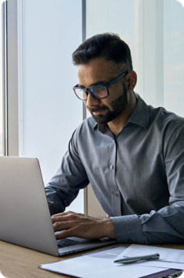 A man looking at a laptop on a table.