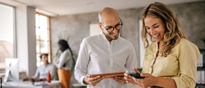 A man and woman looking at a tablet.