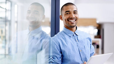 A man smiling in a blue shirt.