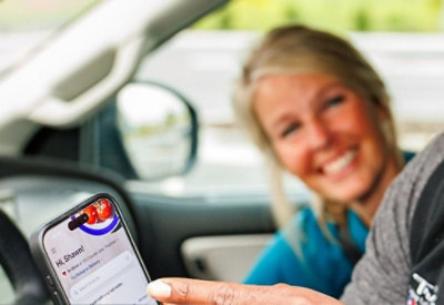 Person showing a mobile app inside a car