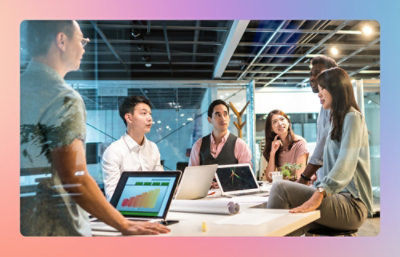 A group of people sitting at a table with laptops and other items.