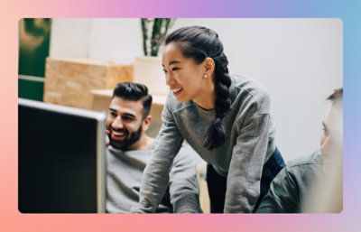 A group of people looking at a laptop with smiling face.