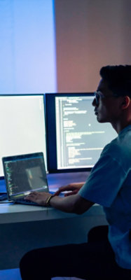 Programmer coding on multi‑screen setup