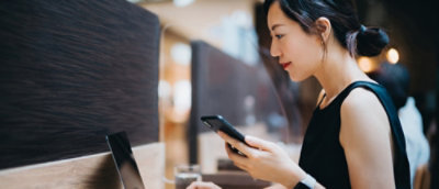 Person checking smartphone at work desk