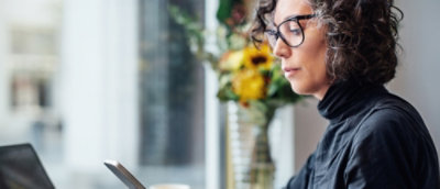 Person using laptop and phone at a desk