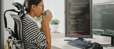 Developer reviewing code on dual monitors