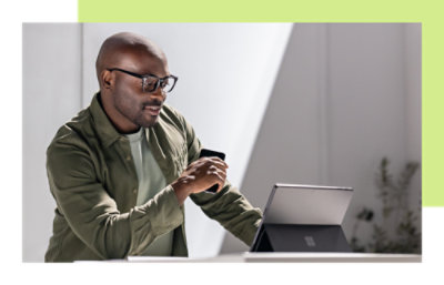 一名穿着绿色夹克的男士正在看手机。