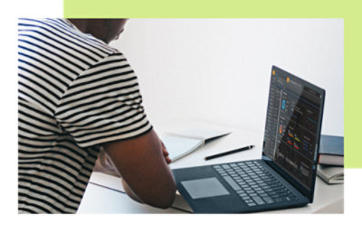 一名穿着条纹衬衫的男士正在看笔记本电脑。