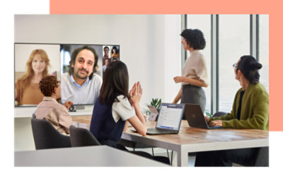 一群人坐在桌前观看视频会议。