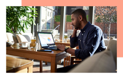 一个人坐在桌前使用笔记本电脑。