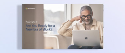 一位男士坐在沙发上使用笔记本电脑。