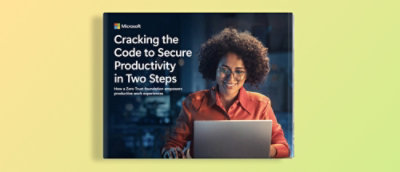 一位卷发女士对着笔记本电脑微笑，旁边牌子上写着 “分两步破解安全生产力密码”。