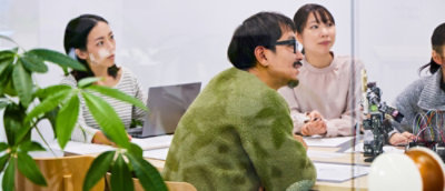 one man and three women watching somthing in the room.