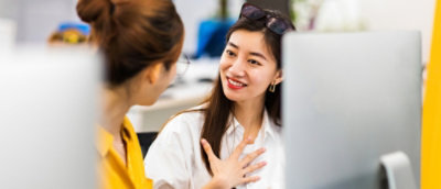 Two women working on computer.