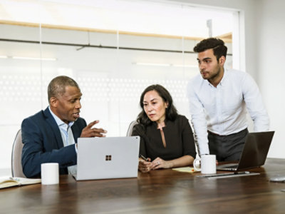 A group of people working on a desk.