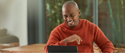A man looking at a laptop and smiling.