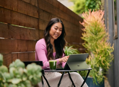 A woman sitting at a table with a Tab.