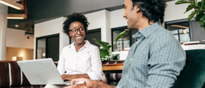 A man and woman looking at a laptop.