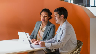 A man and women working on a laptop.