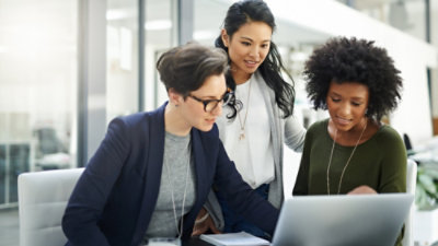 A group of women looking at a laptop.