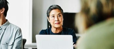 A person sitting at a table with a laptop.