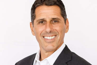 A man in a suit smiling at the camera.