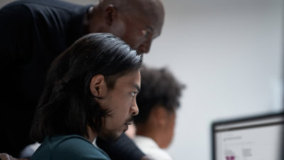 Two persons looking into a desktop screen.