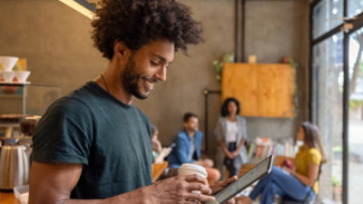 一位微笑的男士手持咖啡杯。