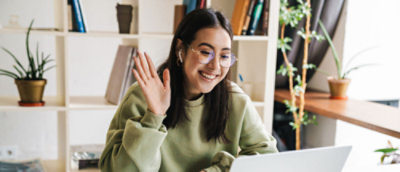 コンピューターに向かって手を振る女性。