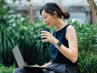 A woman sitting at a table using a laptop.