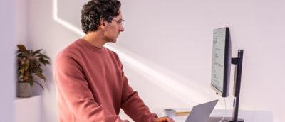 A man in pink shirt working on the laptop