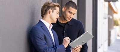 Two people discussing while looking at the tablet