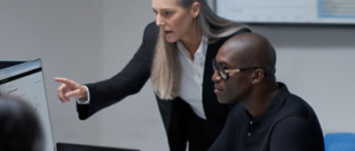 A women showing desktop screen to a women.