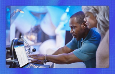 A picture of a woman and man pointing to a screen and discussing