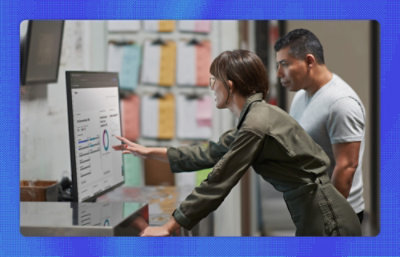 A man and a woman looking at the screen and discussing
