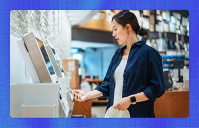 A woman in a blue shirt standing near a row of white rectangular objects in a store.