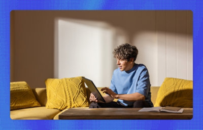 A person sitting on a couch using a laptop.
