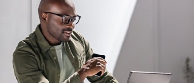 A man wearing glasses looking at a computer.