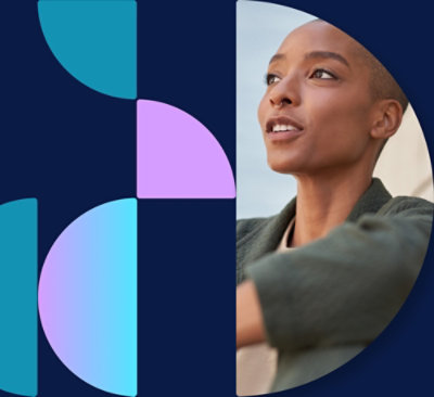 Una mujer con gafas y chaqueta marrón claro usando un ordenador portátil.