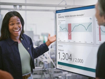 A person presenting a graph on a screen