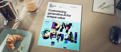 A book about DIY Gen AI rests on a table with a mouse, pen, coffee mug, and a snack beside it.