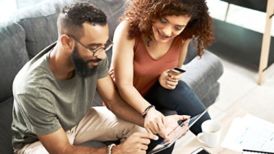 A man and a woman looking at a tablet.