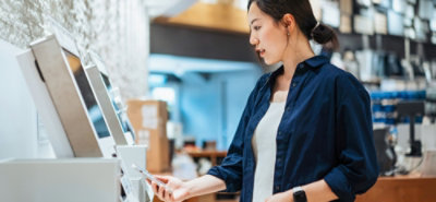 A woman scanning her phone in a machine.