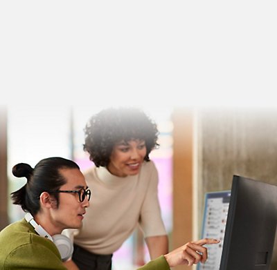 Two people looking at the screen and discussing