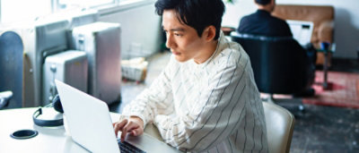 A man sitting at a desk using a laptop.