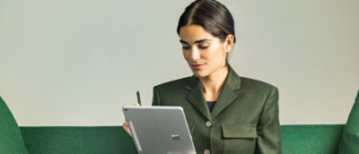 A woman sitting in office environment and looking at the screen