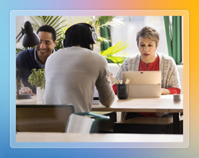  Two colleagues reviewing documents together at a desk in a workspace.