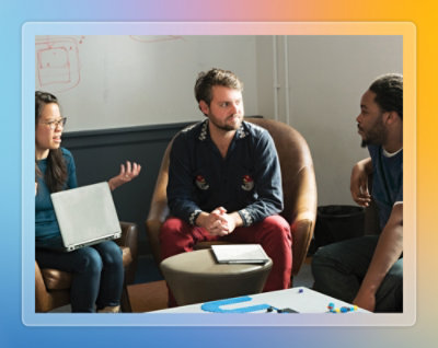 Two people reviewing information on a tablet in an open office environment.