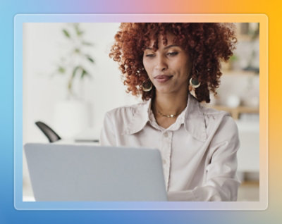  Person working on a laptop at a desk in a bright office space.